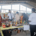 Ann Baker, first left, showcases one of her products to Dr. Ritesh Tularam, Deputy Chief Education Officer (Technical), at the UGIRIE Exhibition of Innovation, Research, and Entrepreneurship.