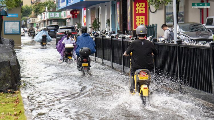 Residents commute in the rain in Jinhua City, east China's Zhejiang Province, July 11, 2025. /VCG