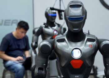 A staff member debugs a humanoid robot at a robot company in Shenzhen, south China's Guangdong Province, June 25, 2025. (Xinhua/Li An)