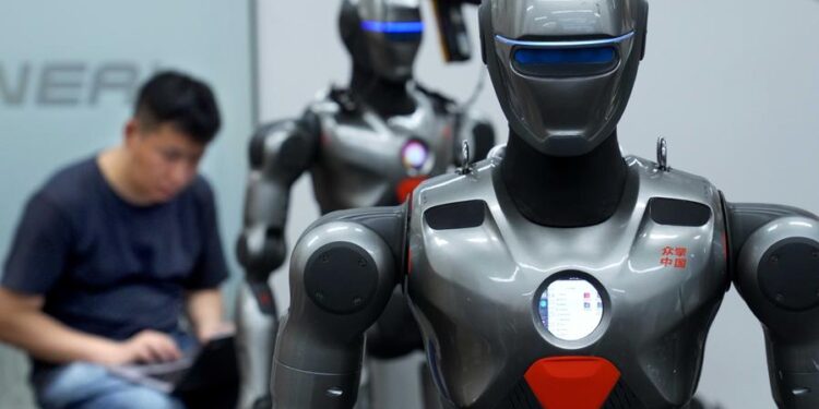 A staff member debugs a humanoid robot at a robot company in Shenzhen, south China's Guangdong Province, June 25, 2025. (Xinhua/Li An)