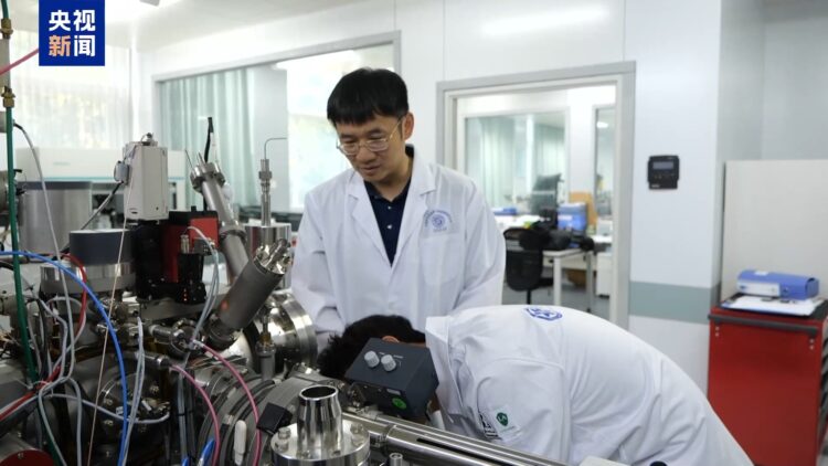 Yang Wei (L), a researcher at the Institute of Geology and Geophysics under the Chinese Academy of Sciences, studies lunar samples with his colleague in Beijing, China. /CMG