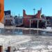 General Secretary of the Guyana Trades Union Congress Lincoln Lewis and the burnt out remains of the GTUC headquarters.