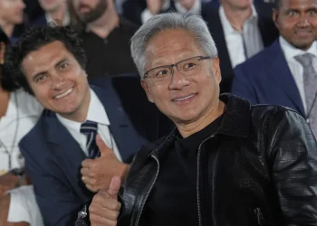 Nvidia CEO Jensen Huang poses for a photo before President Donald Trump speaks during an AI summit at the Andrew W. Mellon Auditorium, Wednesday, July 23, 2025, in Washington. (AP Photo/Julia Demaree Nikhinson)