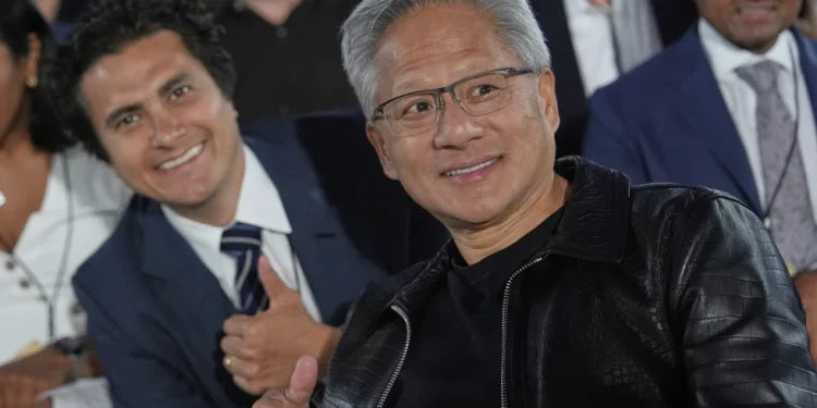 Nvidia CEO Jensen Huang poses for a photo before President Donald Trump speaks during an AI summit at the Andrew W. Mellon Auditorium, Wednesday, July 23, 2025, in Washington. (AP Photo/Julia Demaree Nikhinson)