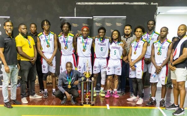 Members of the University of Guyana Trojans celebrate with their coaches; Sports Organiser, Osafa Dos Santos; and supporters following their big win at the Cliff Anderson Sports Hall
