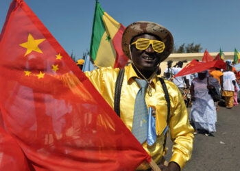 Friendly welcome … people in Dakar prepare to welcome the Chinese president in 2009. Photograph: Seyllou/AFP/Getty Images