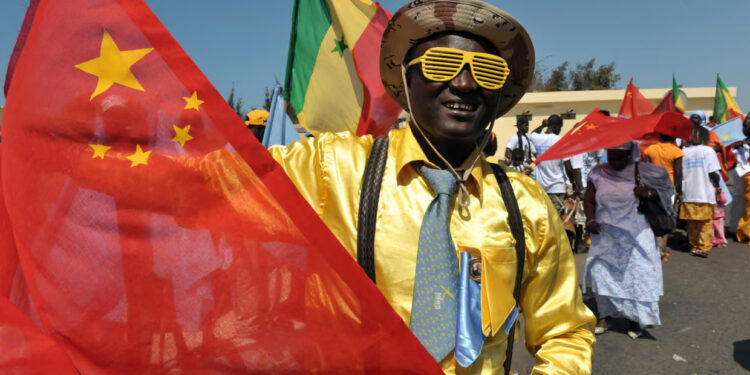 Friendly welcome … people in Dakar prepare to welcome the Chinese president in 2009. Photograph: Seyllou/AFP/Getty Images