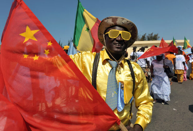 Friendly welcome … people in Dakar prepare to welcome the Chinese president in 2009. Photograph: Seyllou/AFP/Getty Images