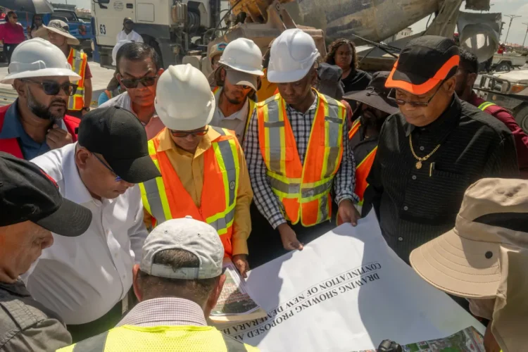Minister of Public Works, Bishop Juan Edghill, Minister of Housing, Collin Croal and a technical team examine the layout for the connector road