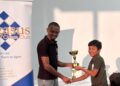 Julian Mohabir receiving his first-place trophy from FM Anthony Dayton.