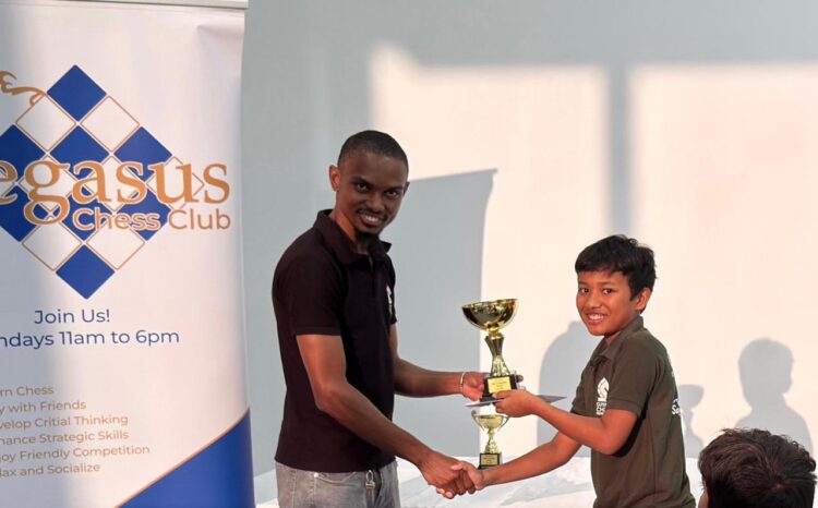 Julian Mohabir receiving his first-place trophy from FM Anthony Dayton.