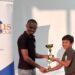 Julian Mohabir receiving his first-place trophy from FM Anthony Dayton.