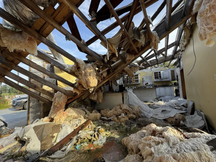 A collapsed roof and insulation cover what used to be Buddy Anthony’s kitchen on Thursday, Aug. 14, 2025, in Tylertown, Miss. (AP Photo/Sophie Bates)