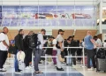 Travelers Stand in line at a security checkpoint before boarding their international flights at Dallas Fort Worth International Airport, Friday, Aug. 29, 2025, in DFW Airport, Texas. AP Photo/Tony Gutierrez