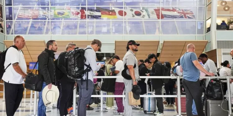 Travelers Stand in line at a security checkpoint before boarding their international flights at Dallas Fort Worth International Airport, Friday, Aug. 29, 2025, in DFW Airport, Texas. AP Photo/Tony Gutierrez