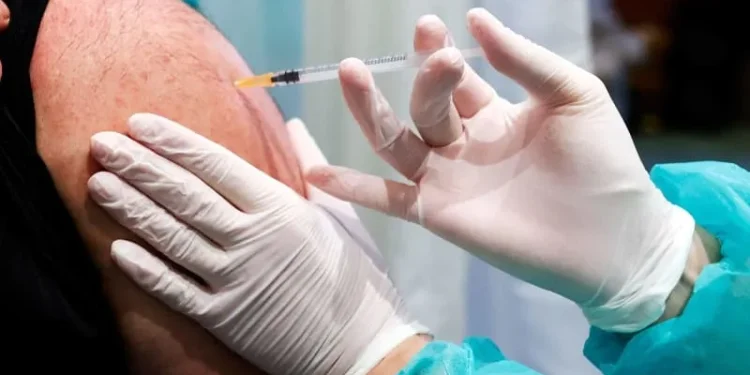 A doctor inoculates a patient with a vaccine against Coronavirus. Carsten Koall/dpa