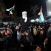 A man waves Palestinian flags as Palestinians react to news on a ceasefire deal with Israel, in Deir Al-Balah in the central Gaza Strip, January 15, 2025.