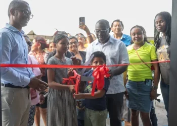 Minister within the Office of the Prime Minister, Kwame McCoy and the villagers of Swan cutting the ribbon at the commissioning of the new market square.