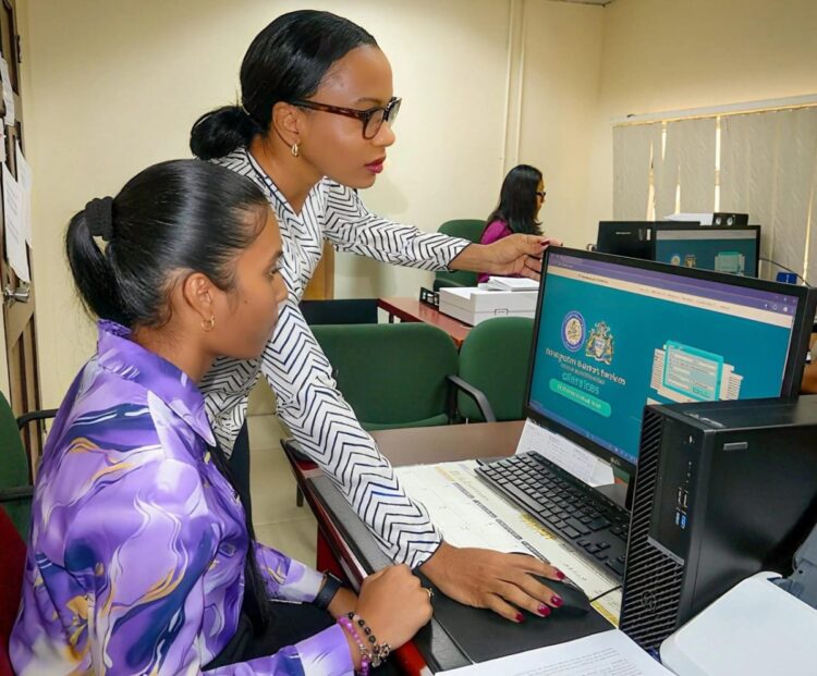 Minister of Home Affairs Oneidge Walrond navigates the platform along with immigration staff