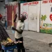 A vendor sells sugarcane next to the entrance of the Doctors Without Borders (MSF) clinic in Port-au-Prince, Haiti, Wednesday, Oct. 15, 2025, after the organization announced the facility’s closure due to ongoing violence. (AP Photo/Odelyn Joseph)