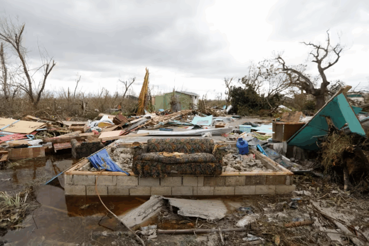 Community members sift through storm-tossed debris in Black River, Jamaica, days after Hurricane Melissa swept the coast. Photo Credit - Matias Delacroix
