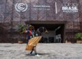 A performer wearing traditional attire poses for a photo in front of the COP30 venue in Belem, Brazil, Nov. 6, 2025. (Xinhua/Wang Tiancong)