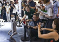 Visitors interact with a robot dog at the 2025 World AI Conference (WAIC) in East China's Shanghai, July 29, 2025. [Photo/Xinhua]