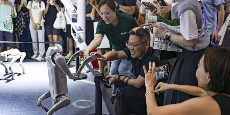Visitors interact with a robot dog at the 2025 World AI Conference (WAIC) in East China's Shanghai, July 29, 2025. [Photo/Xinhua]