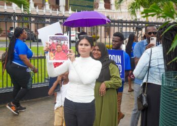 Hana Mohamed (in white) hold a photo of Speaker Manzoor Nadir (Team Mohamed's photo)