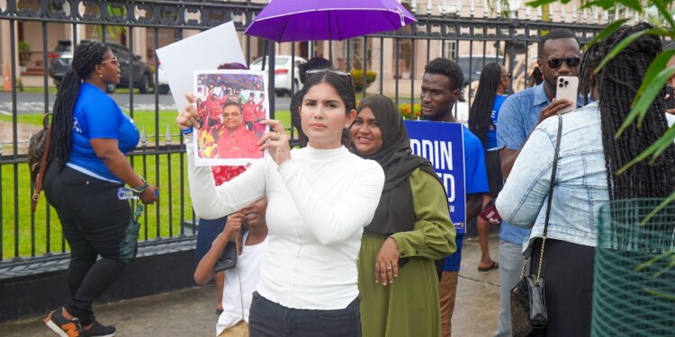 Hana Mohamed (in white) hold a photo of Speaker Manzoor Nadir (Team Mohamed's photo)