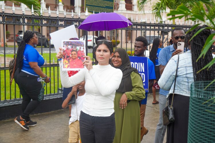 Hana Mohamed (in white) hold a photo of Speaker Manzoor Nadir (Team Mohamed's photo)