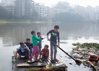 © UNICEF/Jannatul Mawa Children cross a polluted lake on a homemade raft in the Korail slum of Dhaka, Bangladesh.