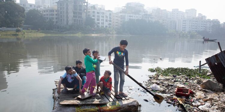 © UNICEF/Jannatul Mawa Children cross a polluted lake on a homemade raft in the Korail slum of Dhaka, Bangladesh.