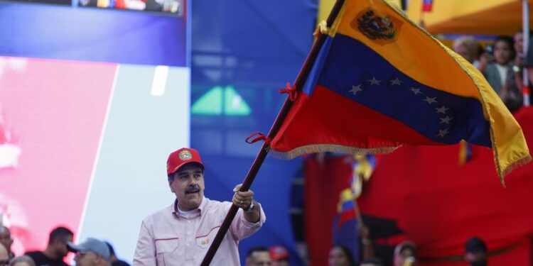 Venezuelan President Nicolas Maduro waves the Venezuelan national flag during a rally in Caracas, capital of Venezuela, Dec. 1, 2025. (Str/Xinhua)