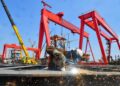 A worker prefabricates steel for Bohai Oilfield platform at an intelligent manufacturing base in Tianjin, north China, March 30, 2025. (Photo by Du Penghui/Xinhua)
