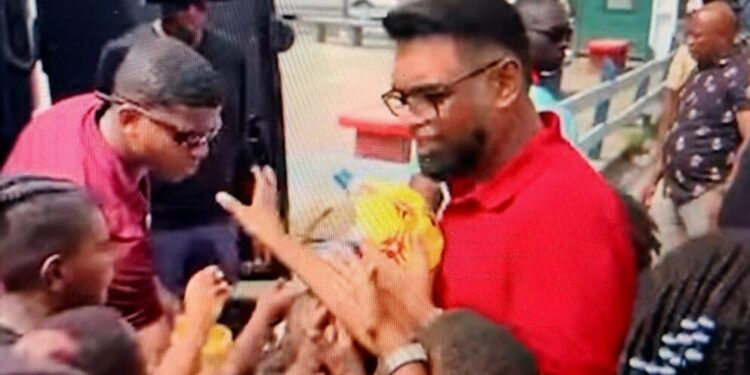 screengrab of President Irfaan Ali sharing out toys in Albouystown
