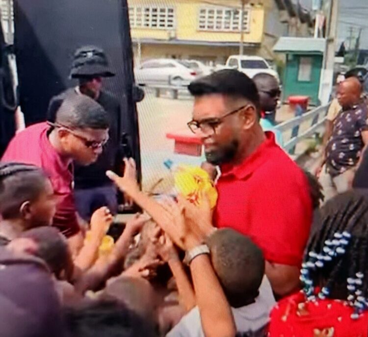 screengrab of President Irfaan Ali sharing out toys in Albouystown