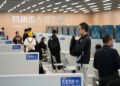 Jobseekers gather information at an employer's stand during a job fair held in Hangzhou, Zhejiang province, on Nov 12. [Photo/Xinhua]