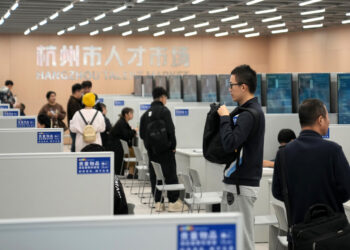 Jobseekers gather information at an employer's stand during a job fair held in Hangzhou, Zhejiang province, on Nov 12. [Photo/Xinhua]