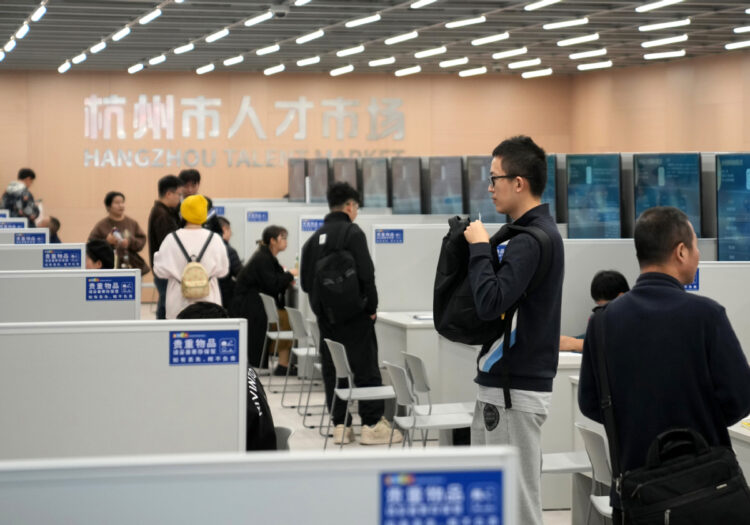 Jobseekers gather information at an employer's stand during a job fair held in Hangzhou, Zhejiang province, on Nov 12. [Photo/Xinhua]