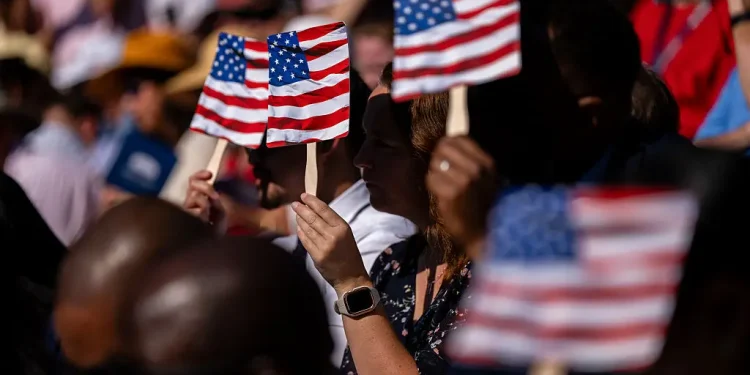 New US citizens use handheld fans to take shade from the sun during a naturalization ceremony at George Washington's Mount Vernon in Mount Vernon, Virginia, US, on Friday, July 4, 2025. Kent Nishimura/Bloomberg via Getty ImagesKent Nishimura—Bloomberg via Getty Images