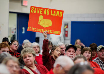 A community member holds a sign against a plan of Talen Energy to rezone land from agricultural to industrial to build a data center, at the Montour County Planning Commission meeting in Danville, Pennsylvania, U.S. November 19, 2025. REUTERS/Hannah Beier Purchase Licensing Rights