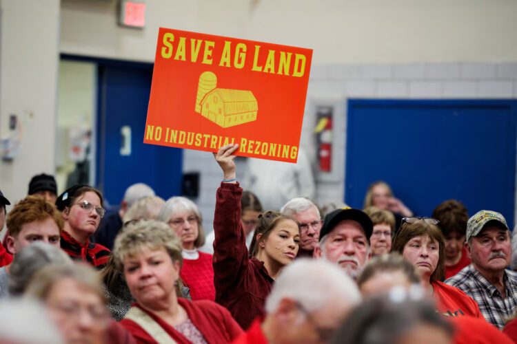 A community member holds a sign against a plan of Talen Energy to rezone land from agricultural to industrial to build a data center, at the Montour County Planning Commission meeting in Danville, Pennsylvania, U.S. November 19, 2025. REUTERS/Hannah Beier Purchase Licensing Rights