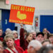 A community member holds a sign against a plan of Talen Energy to rezone land from agricultural to industrial to build a data center, at the Montour County Planning Commission meeting in Danville, Pennsylvania, U.S. November 19, 2025. REUTERS/Hannah Beier Purchase Licensing Rights
