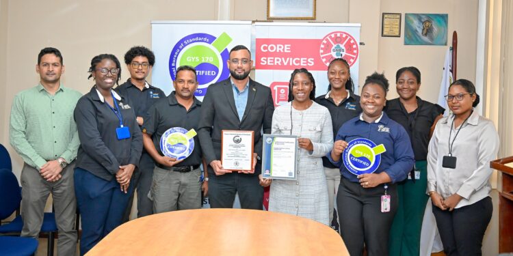(L-R) GFSL Quality Officer, Abidin Mohamed, PS-Ministry of Home Affairs Andre Ally and Director(ag) of GFSL Ms. Charis Griffith along with staff of GFSL