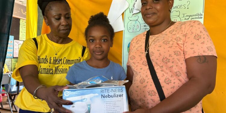 Morvia Reid Williams (L) handing out a nebulizer at medical mission in Little London, Westmoreland.