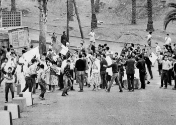 Young Muslims gather around the green and white FLN rebel flag in Diar el Mahcoul, a suburb of Algiers, ignoring French orders to stay at home, Oct. 31, 1969. (AP Photo/ H. Babout, file)