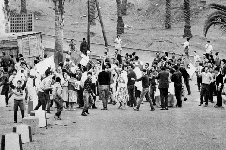 Young Muslims gather around the green and white FLN rebel flag in Diar el Mahcoul, a suburb of Algiers, ignoring French orders to stay at home, Oct. 31, 1969. (AP Photo/ H. Babout, file)