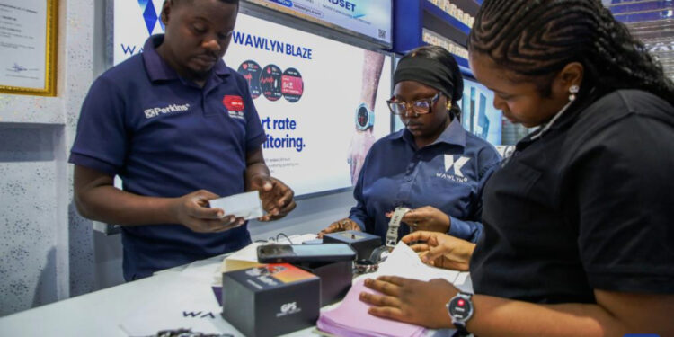 Staff members assist customers at a shop selling electronic products at the East Africa Commercial and Logistics Center (EACLC) in Dar es Salaam, Tanzania, Dec. 19, 2025. (Xinhua/Emmanuel Herman)