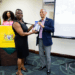 His Excellency Professor Compton Bourne, OE, presents a copy of his book to Dr Simone Bernard, Acting University Librarian